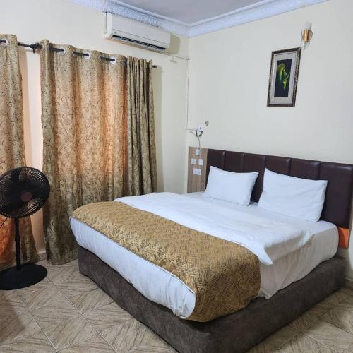 um quarto com uma cama grande em um quarto em EcoSignature ABK Hotel, Ibadan em Ibadan