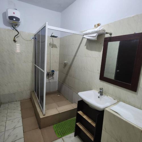 um banheiro com chuveiro, pia e espelho em EcoSignature ABK Hotel, Ibadan em Ibadan