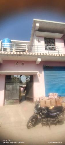 a motorcycle parked in front of a house at Brijendra Homestay in Khatīma