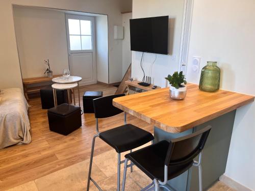 a living room with a table and chairs and a bed at Charmante petite maison, à 5 mn de Blois in Vineuil