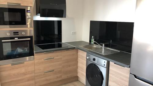 une cuisine avec un évier et une cuisinière dans l'établissement Private bedroom with private bathroom & toilet in a shared flat, à Orléans