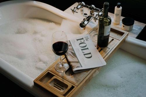 a glass of wine sitting in a bath tub with foam at Spread Eagle in London