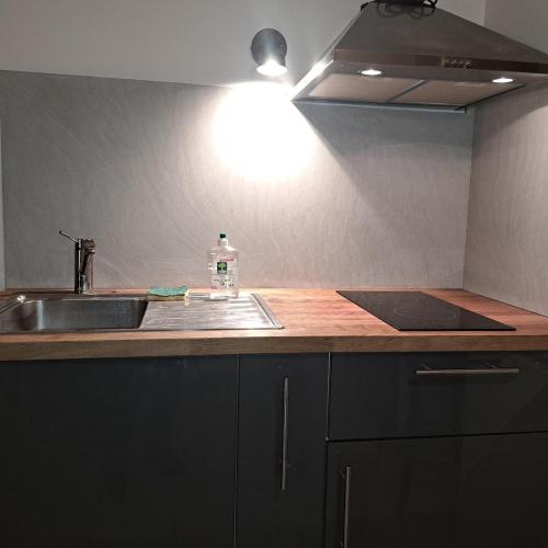 - un comptoir de cuisine avec évier et une bouteille d'eau dans l'établissement L'Atelier Rochecardon, à Lyon