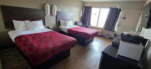 a hotel room with two beds and a window at Econo Lodge Fort Knox in Radcliff
