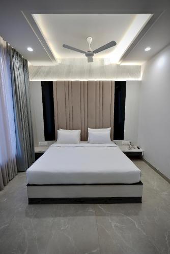 a bedroom with a bed with a ceiling fan at Hotel Elinor By Dazzling Hotels & Resorts in Agra