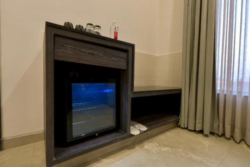 a fireplace with a television in a room at Hotel Elinor By Dazzling Hotels & Resorts in Agra