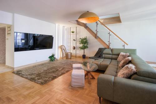 a living room with a couch and a tv at Apartament w centrum - duplex penthouse in the centre with terrace and air conditioning in Krakow