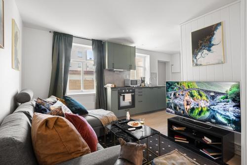a living room with a couch and a flat screen tv at Nord Apartments in Trondheim