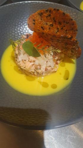 a plate of food with a piece of meat and yellow sauce at Mas des Pelissiers Chambre & Table d'hote in Sabran