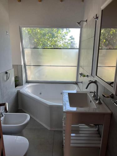 a bathroom with a tub and a toilet and a sink at Casita Amarilla in Miramar