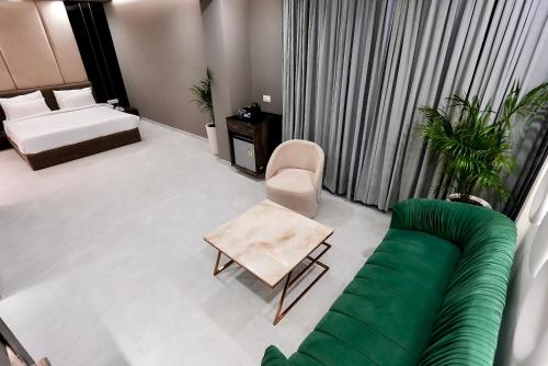 a living room with a couch and a chair at Hotel Elinor By Dazzling Hotels & Resorts in Agra