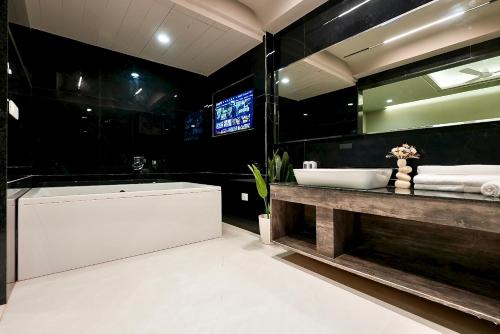 a bathroom with a tub and a large mirror at Hotel Elinor By Dazzling Hotels & Resorts in Agra