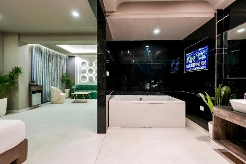 a bathroom with a tub and a tv in a room at Hotel Elinor By Dazzling Hotels & Resorts in Agra