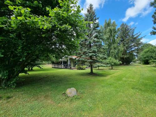 a large yard with trees and a house at Unobstructed Summer House In Lovely Langeland in Tranekær