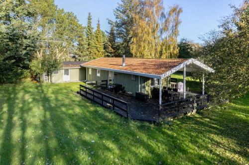 a house with a deck in a yard at Unobstructed Summer House In Lovely Langeland in Tranekær