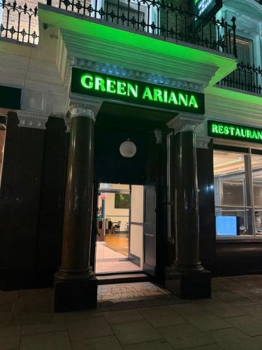 a green entrance to a green arambalam sign on a building at Green Ariana Hotel - near Wembley and central London in London