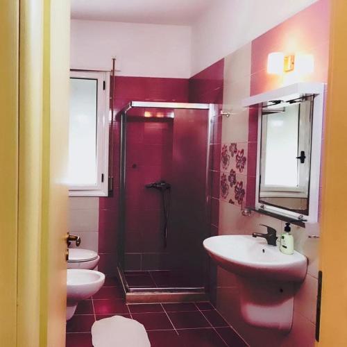 a bathroom with a shower and two sinks and a toilet at Rezidenca radhima in Vlorë