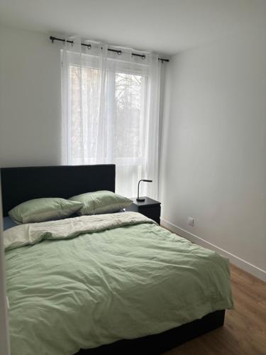 een slaapkamer met een bed en een raam bij Le jardin secret de Sèvres -proche de Paris in Sèvres