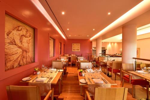a restaurant with tables and chairs and a painting on the wall at Pestana Grand Ocean Resort Hotel in Funchal