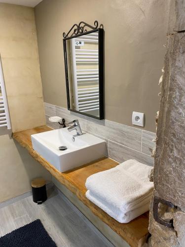 a bathroom with a sink and a mirror at Mas des Pelissiers Gîte in Sabran