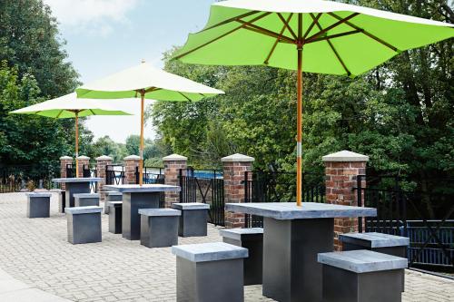 a group of tables and chairs with umbrellas at Novotel York Centre in York