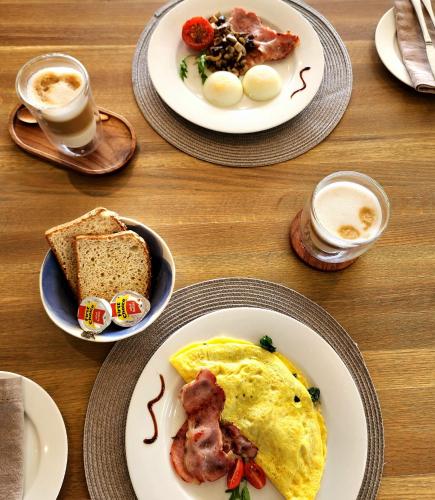 a table topped with plates of breakfast foods and coffee at Waves of Grace Seafront Villa in Herolds Bay