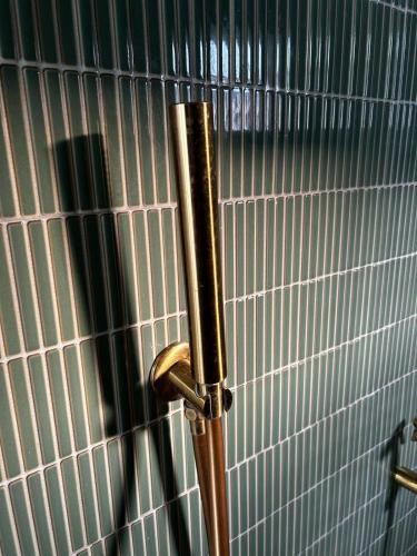 a metal pole in a bathroom with white tiles at Rana Mahal - a Boutique Place in Varanasi