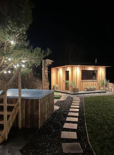 a small wooden house with lights on it at night at Rostrevor Mountain Lodge - Glamping Pods - Revive Sauna & Hot Tubs in Rostrevor