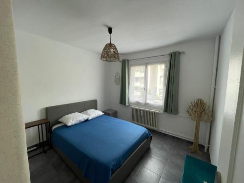 une chambre avec un lit bleu et une fenêtre dans l'établissement Les Pins d'Antibes, à Antibes