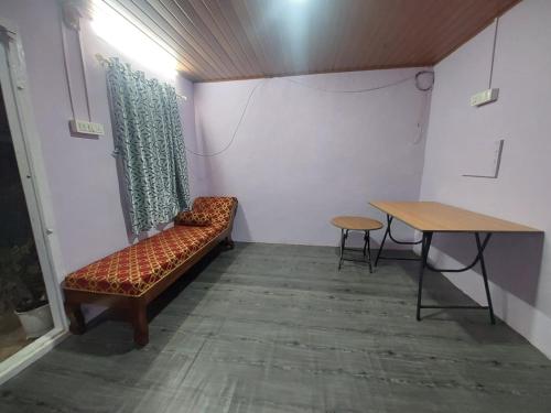 a room with a bench and a table in it at Royal villa Homestay in Munnar