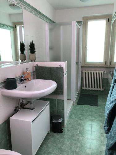 a white bathroom with a sink and a mirror at Miralago Casa Vacanze in Villa di Chiavenna