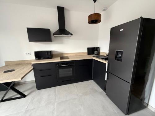 a kitchen with a black refrigerator and a table at E casette in Oletta