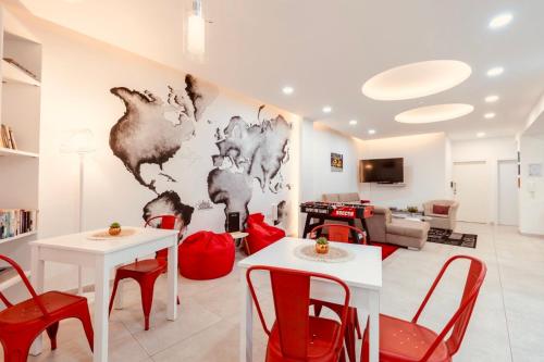a living room with white tables and red chairs at LA 88 Boutique in St Paul's Bay