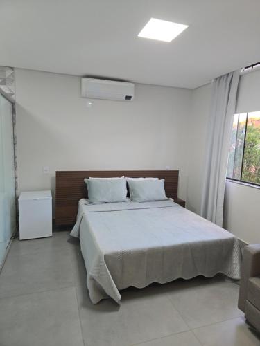 a bedroom with a large bed and a window at AR Pousada in Santa Bárbara