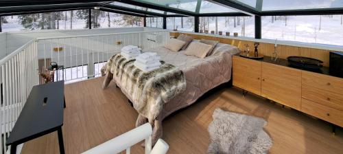 a bedroom with a large bed in a glass house at Levi Sky Igloo with private sauna and hot tub in Levi