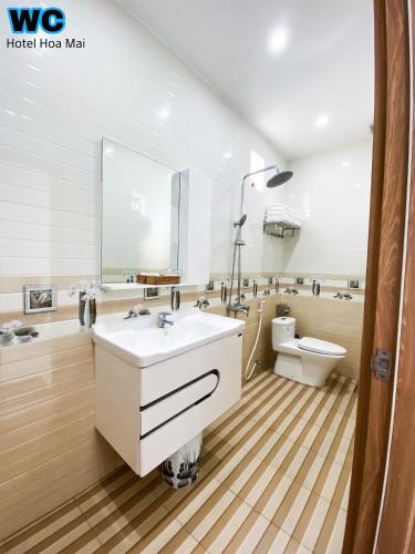 a bathroom with a white sink and a toilet at Hotel Hoa Mai in Con Dao
