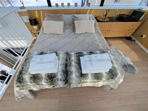 a large bed with a blanket and pillows on it at Levi Sky Igloo with private sauna and hot tub in Levi