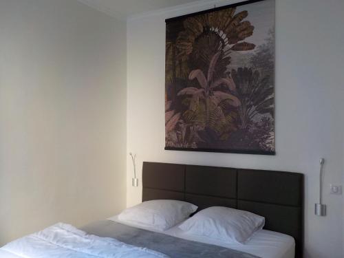 - une chambre avec un lit et un tableau au-dessus dans l'établissement LA REPOSEE, à Trouville-sur-Mer