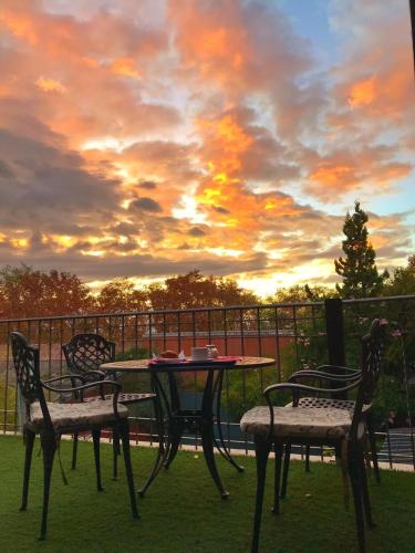 a table and chairs on a patio with a sunset at Hotel Francia in San Rafael