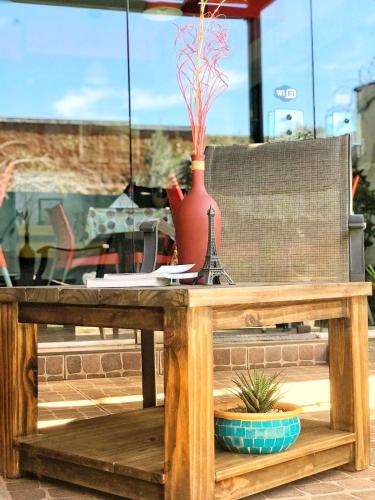 a wooden table with a vase and a potted plant on it at Hotel Francia in San Rafael