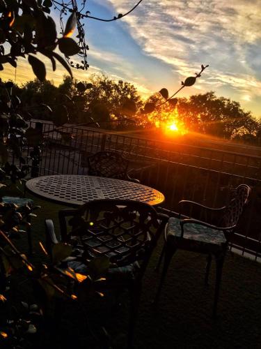 a table and chairs with the sunset in the background at Hotel Francia in San Rafael