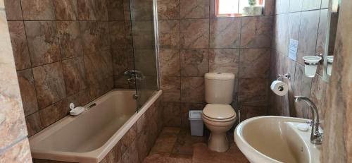 a bathroom with a toilet and a tub and a sink at Field and Stream in Dullstroom
