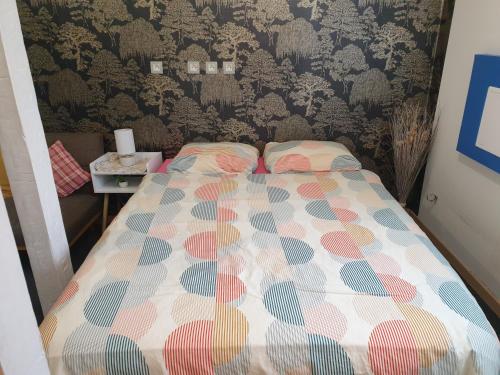 a small bedroom with a bed with a colorful comforter at Les hirondelles 69 in Colmar