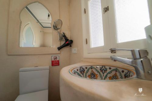 a bathroom with a sink and a mirror and a toilet at PALACIO AL ANDALUS in Chefchaouene