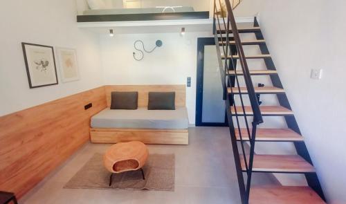 a room with a bed and a spiral staircase at LA PLAZA luxury suites NEA VRASNA in Nea Vrasna