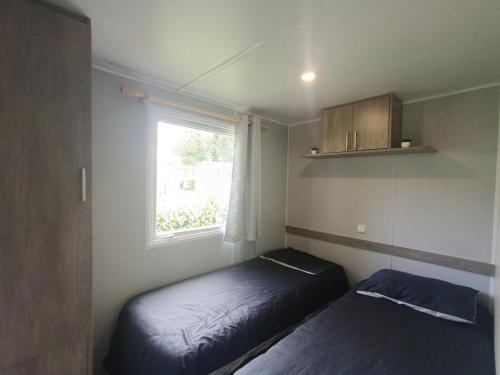 une petite chambre avec un lit et une fenêtre dans l'établissement horizon bleu, à Trégunc