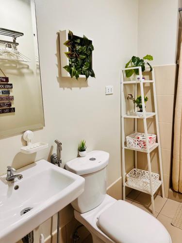 a bathroom with a white toilet and a sink at The ARC Suites in Manila