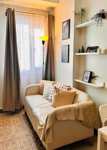 a living room with a couch in front of a window at The ARC Suites in Manila