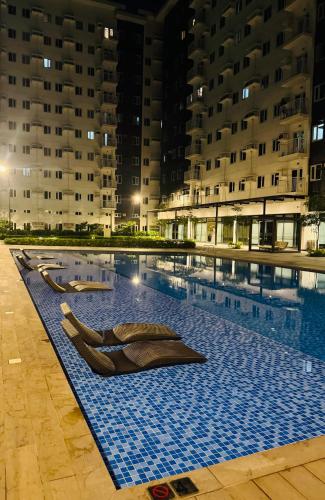 a swimming pool with two chaises in the middle of a building at The ARC Suites in Manila