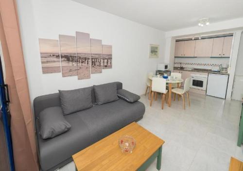 un salon avec un canapé et une table dans l'établissement Appartement équipé CALPE Espagne, 4 couchages, terrasse, piscines, climatisation, garage, WIFI gratuits, à Calp
